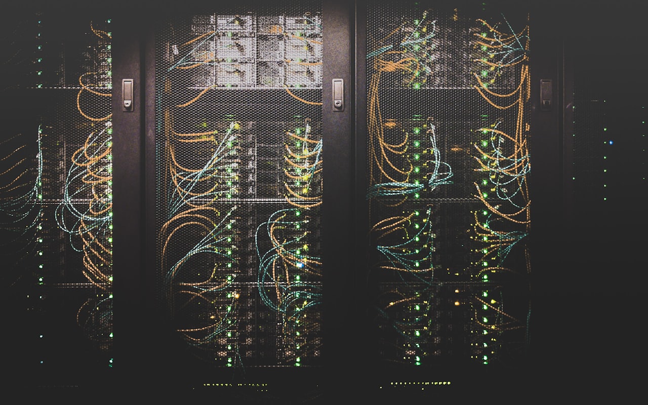 Dark data centre racks with fibre cabling representing the origin infrastructure and transit capacity protected during a DDoS attack